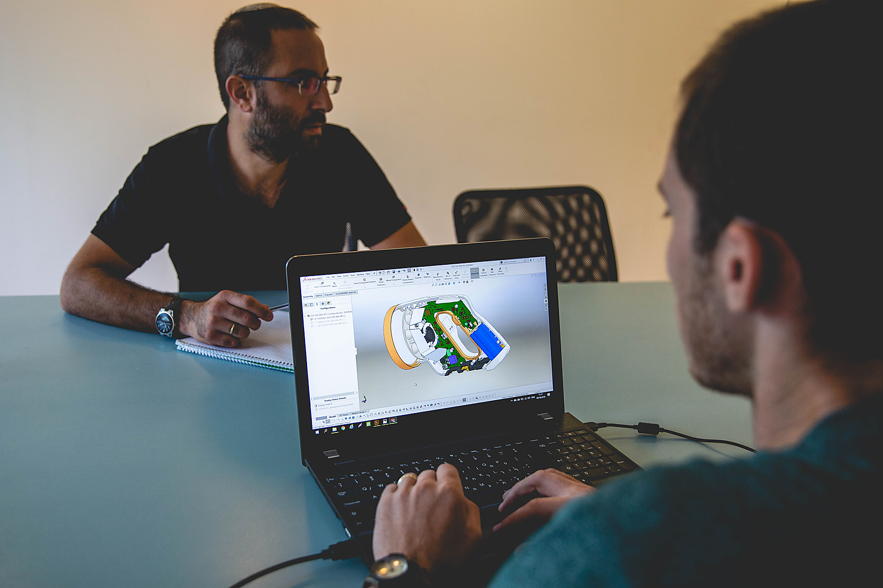 Kii.am engineers reviewing a SOLIDWORKS 3D model of a handheld device